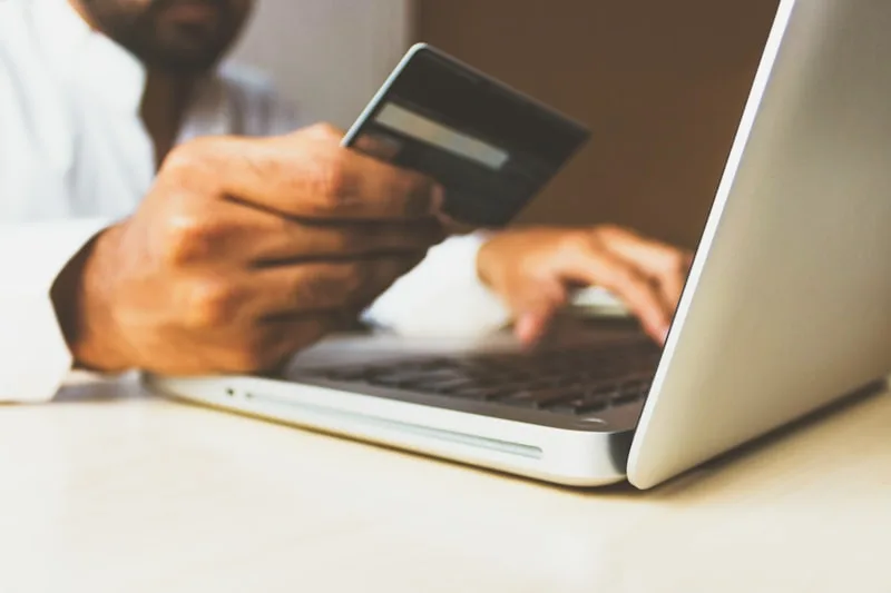 Personne réalisant un achat en ligne avec carte bancaire